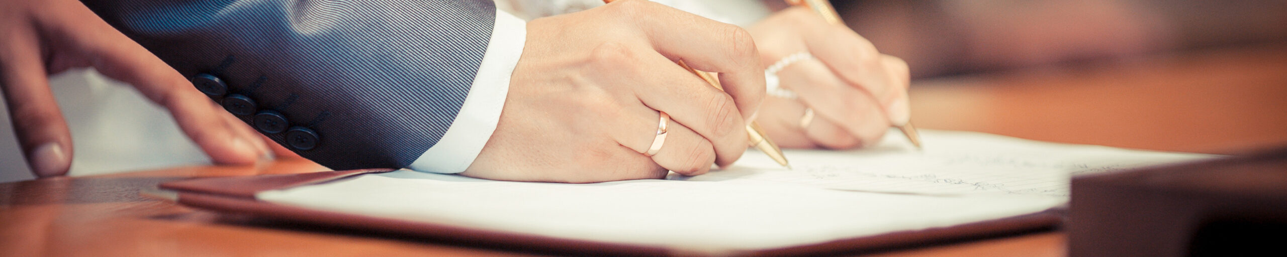Hochzeitspaar unterschreibt Heiratsurkunde