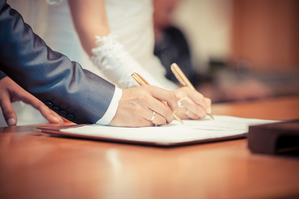 Hochzeitspaar unterschreibt Heiratsurkunde