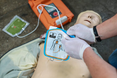 Training mit einem automatischen Defibrillator an einer Puppe