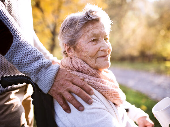 Eine Männerhand auf der Schulter einer Seniorin