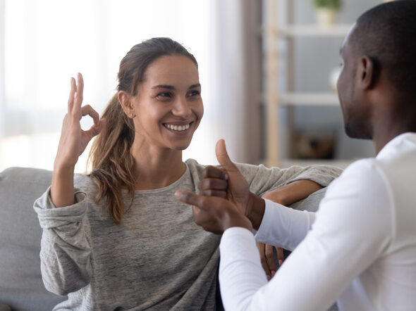 Ein Mann und eine Frau unterhalten sich in Gebärdensprache.