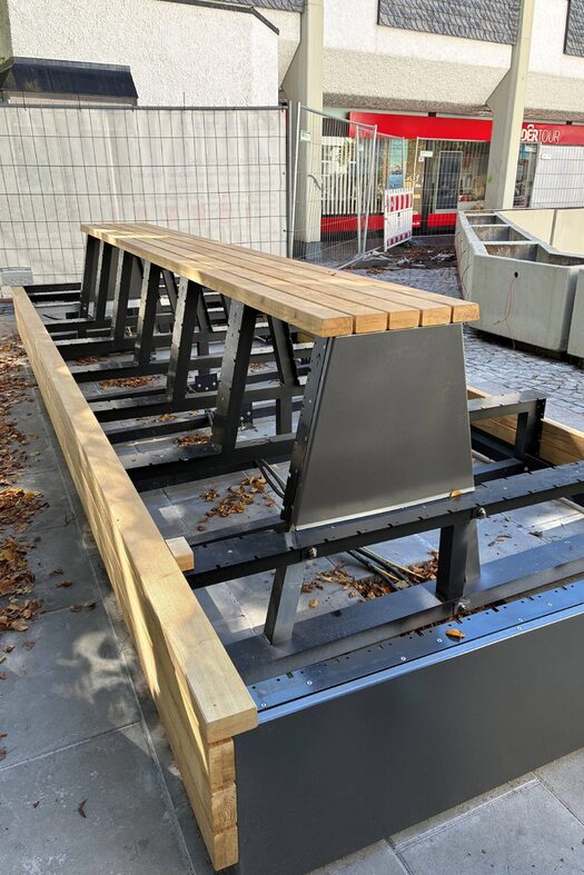 Sitzmöbel oberhalb und auf dem Platz laden zum Verweilen ein.