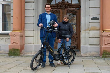 Oberbürgermeister Dominik Sauerteig und Kirsten Köhn stehen mit einem der neuen Dienstfahrrädern vor dem Rathaus.