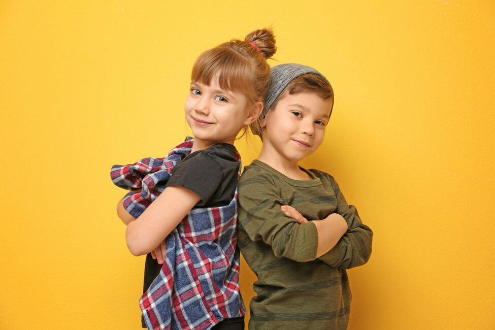 Ein Junge und ein Mädchen vor gelbem Hintergrund