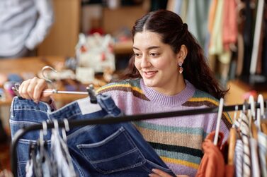 Portrait,Of,Smiling,Middle,Eastern,Female,Customer,Holding,Hanger,With