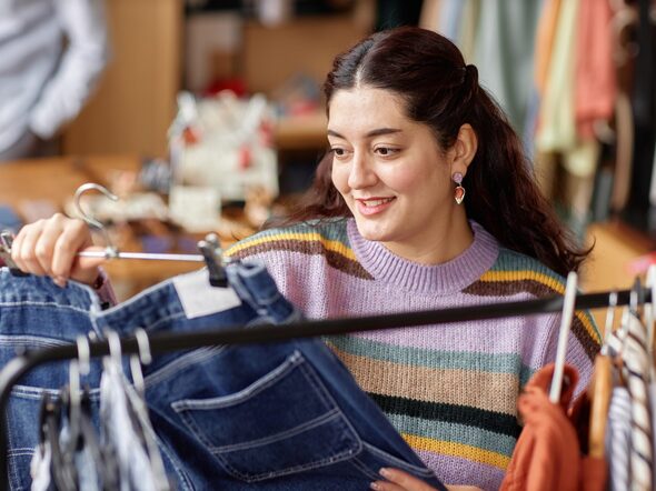 Portrait,Of,Smiling,Middle,Eastern,Female,Customer,Holding,Hanger,With