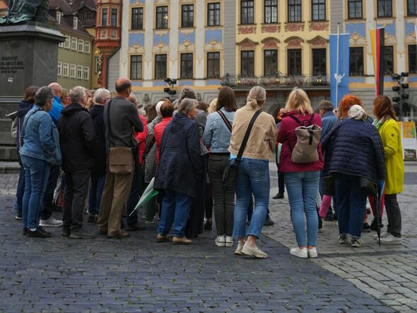 Eine Gruppe während des Abendspazirgangs vor dem Rathaus