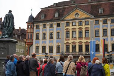 Eine Gruppe während des Abendspazirgangs vor dem Rathaus