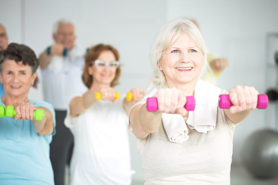 Elderly,Women,Holding,Dumbbells,During,Group,Exercise,Class,For,Senior