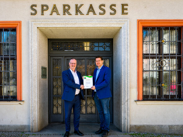 Oberbürgermeister Dominik Sauerteig übergibt Dr. Martin Faber, Vorstandsvorsitzender der Sparkasse Coburg-Lichtenfels, die Urkunde für die Teilnahme am Umwelt- und Klimapakt Bayern.