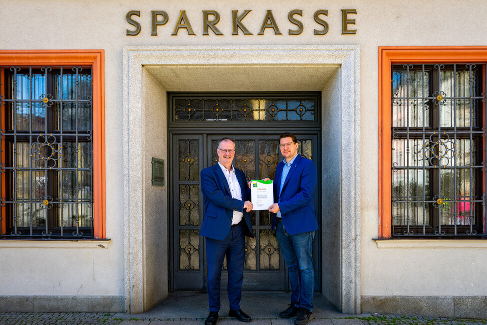 Oberbürgermeister Dominik Sauerteig übergibt Dr. Martin Faber, Vorstandsvorsitzender der Sparkasse Coburg-Lichtenfels, die Urkunde für die Teilnahme am Umwelt- und Klimapakt Bayern.