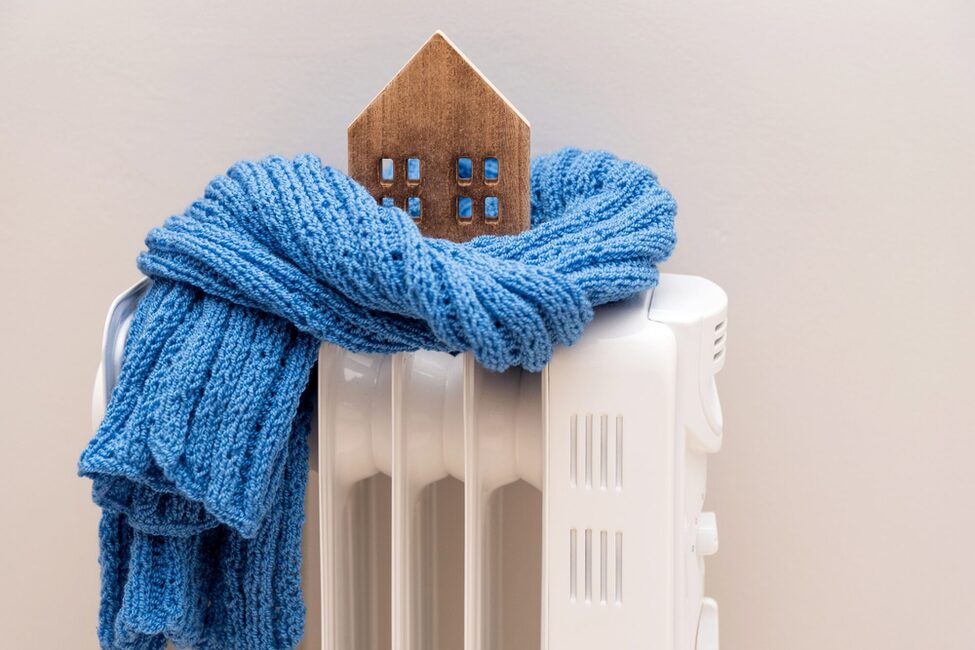 Wooden,Model,House,Wrapped,In,A,Blue,Scarf,On,A