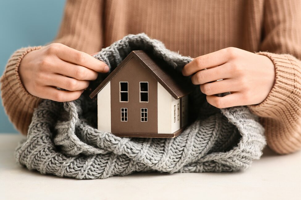 Woman,With,Model,Of,House,And,Warm,Scarf,On,White