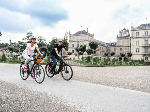 Zwei Fahrradfahrer*innen vor der Ehrenburg
