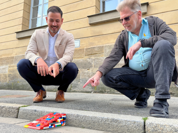 Bürgermeister Can Aydin und der Behindertenbeauftragte Heinz Rembor zeigen, wie Legosteine Hindernisse minimieren können.