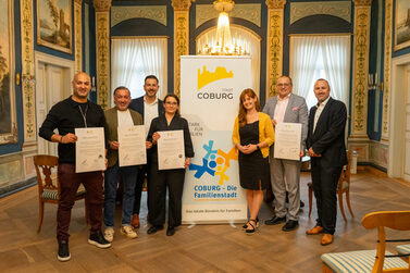 neue Bündispartner bereichern „Coburg – Die Familienstadt“: (v.l.) Nima Khorsandi (Wohnzimmer, Nimassimo Events), Massimo Iannelli-Fard (Nimassimo Events), Can Aydin, 3. Bürgermeister der Stadt Coburg, Sandra Ender (stellv. Geschäftsführerin iSo gGmbH), Bianca Haischberger (Leiterin der Stabsstelle Demografie, Bildung & Familie), Matthias Herpich (Mitglied des Vorstands der VR-Bank Coburg eG), Michael Forkel (Prokurist der VR-Bank Coburg eG)