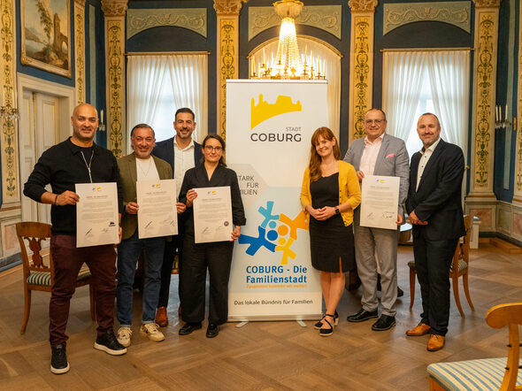 neue Bündispartner bereichern „Coburg – Die Familienstadt“: (v.l.) Nima Khorsandi (Wohnzimmer, Nimassimo Events), Massimo Iannelli-Fard (Nimassimo Events), Can Aydin, 3. Bürgermeister der Stadt Coburg, Sandra Ender (stellv. Geschäftsführerin iSo gGmbH), Bianca Haischberger (Leiterin der Stabsstelle Demografie, Bildung & Familie), Matthias Herpich (Mitglied des Vorstands der VR-Bank Coburg eG), Michael Forkel (Prokurist der VR-Bank Coburg eG)