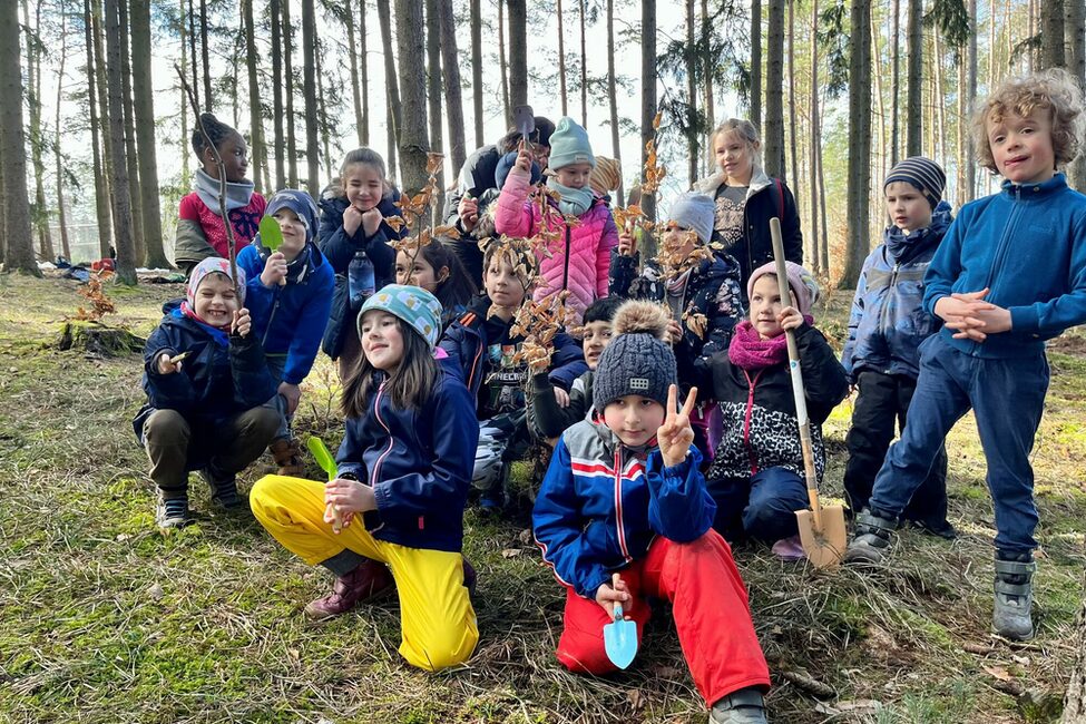Kinder des Bildungshauses der Stadt Coburg pflanzen Bäume im Stadtwald.