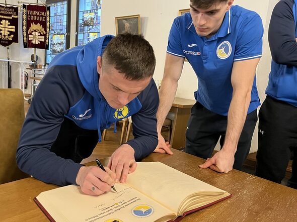 Ein Spieler der ukrainischen Handballnationalmannschaft trägt sich in das Goldene Buch der Stadt Coburg ein