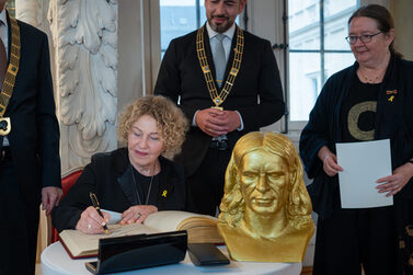 Aghi Mishol, Preisträgerin des Rückertpreises 2025 trägt sich ins Goldene Buch der Stadt ein.