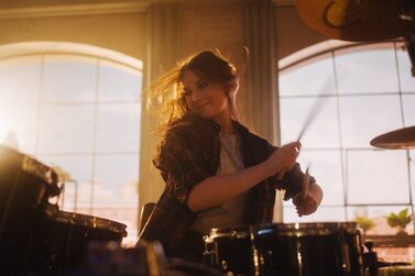 Portrait,Of,A,Young,Female,Playing,Drums,During,A,Band