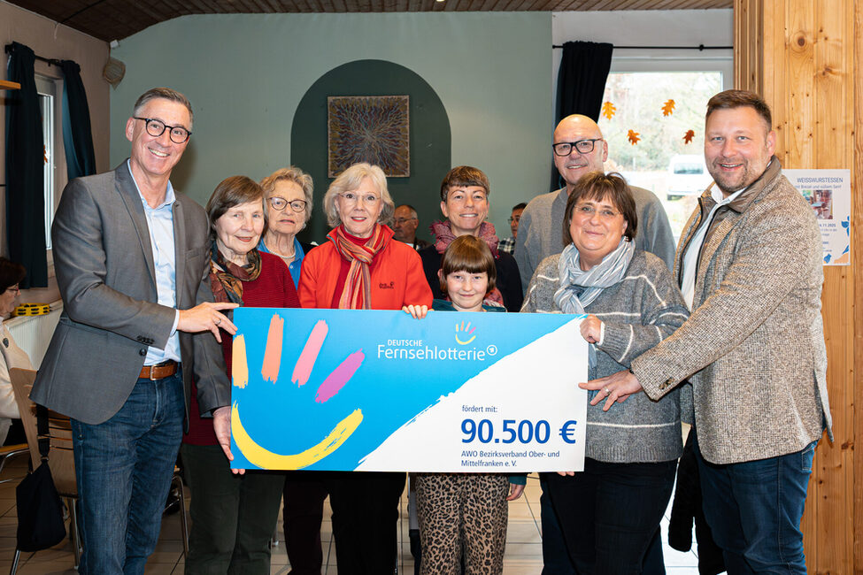 v.l.n.r.: 1. v. l. Holger Diez, Amtsleiter des Sozial- und Versicherungsamtes der Stadt Coburg; 2. Reihe, 5. v. l. Liane Blietzsch, Einrichtungsleiterin des Mehrgenerationenhauses des AWO Bezirksverband Ober- und Mittelfranken e.V.; 1. Reihe, 6 v. l. Birgit Schober, Verwaltungsleiterin Mehrgenerationenhauses der AWO & 1. v. r. Stephan Masch, Repräsentant der Deutschen Fernsehlotterie bei der symbolischen Übergabe der Fördersumme in Coburg gemeinsam mit Nutzern des Quartiersmanagements