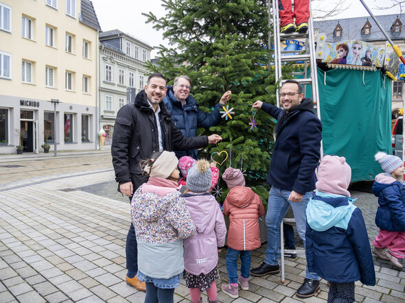 Can Aydin, Hubertus Prinz von Sachsen-Coburg und Gotha und Enrico Pizzato schmücken mit den Kindern aus dem Kinderhaus den Weihnachtsbaum.