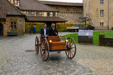 Oberbürgermeister Dominik Sauerteig und Rolf Sander bei einer Fahrt mit dem Flocken Elektrowagen auf der Veste Coburg.
