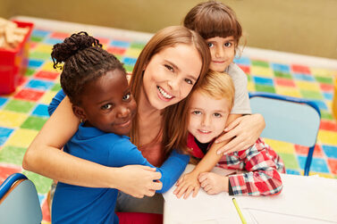 Happy,Woman,As,A,Teacher,Or,Childminder,Together,With,Children
