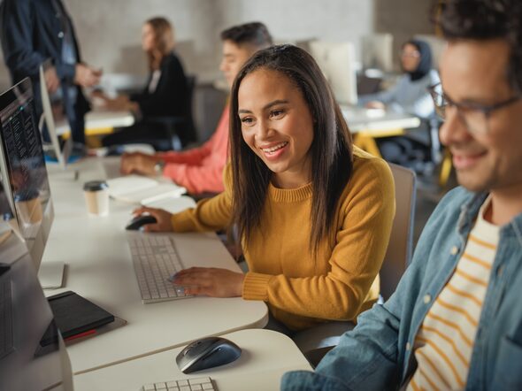 Ein junger Mann und eine junge Frau sitzen vor ihren Computern