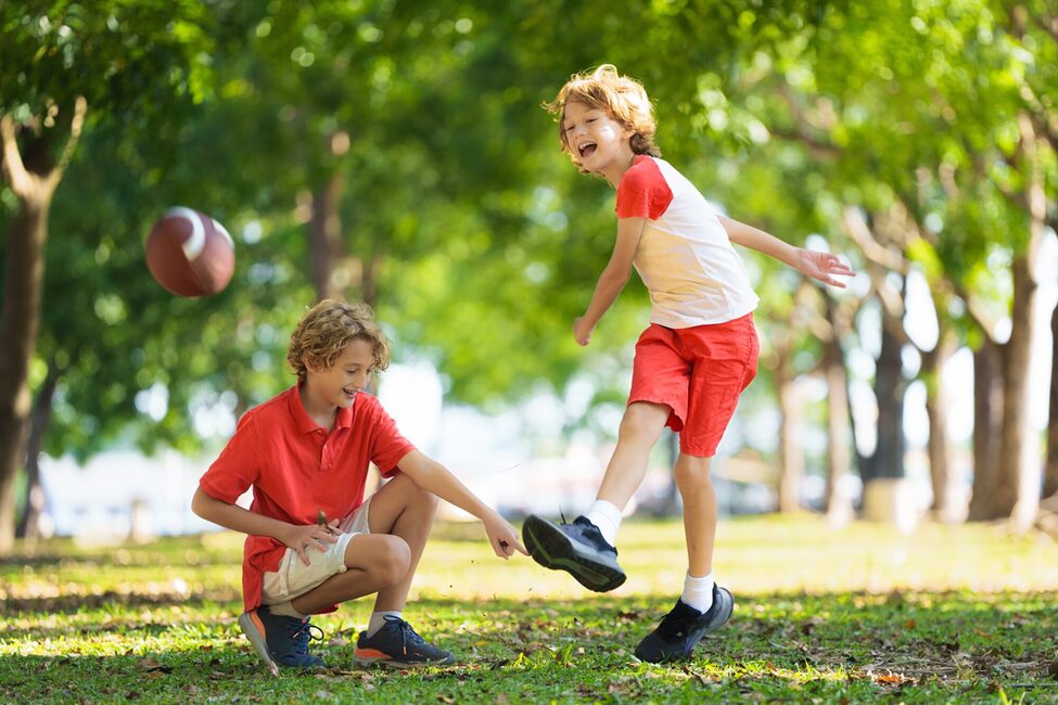Zwei Jungs spielen im Sommer Fußball.