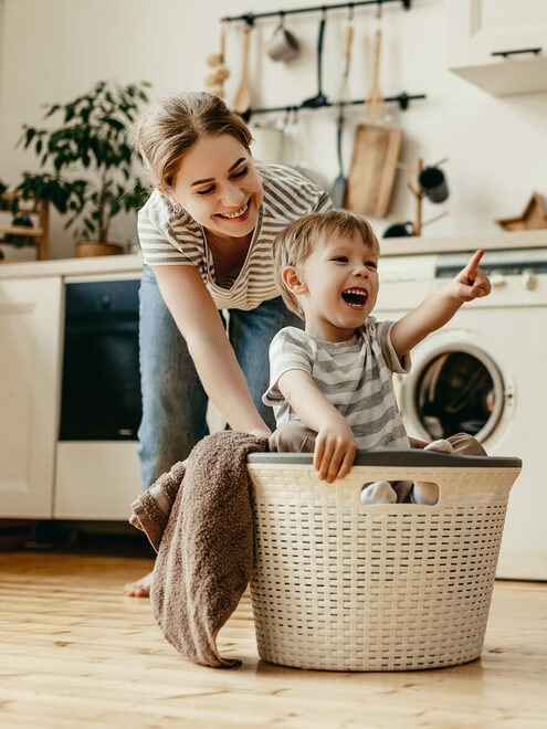 Mutter mit Kind im Wäschekorb