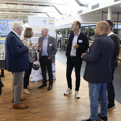 Mehrere Personen stehen in einer Gruppe zusammen und unterhalten sich