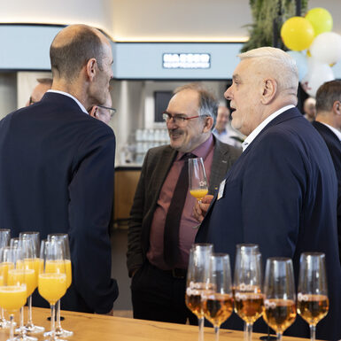 Mehrere Personen stehen in einer Gruppe zusammen und unterhalten sich