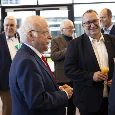 Mehrere Personen stehen in einer Gruppe zusammen und unterhalten sich