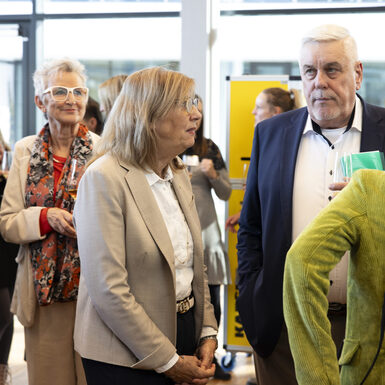 Mehrere Personen stehen in einer Gruppe zusammen und unterhalten sich