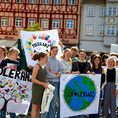 Verschiedene Kinder halten selbst gemaltte Plakate in der Hand auf denen das Wort "Toleranz" abgebildet ist