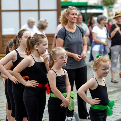Eine Gruppe von Kindern in schwarzer Tanzkleidung steht in einer Reihe hintereinander.