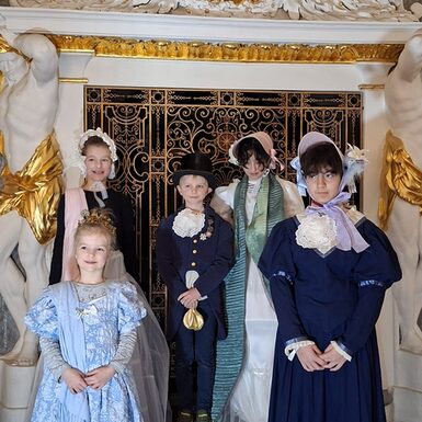 Kinder sind verkleidet wie früher und lächeln in die Kamera.