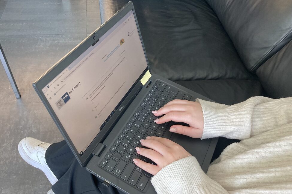 Hände schreiben auf einem Laptop