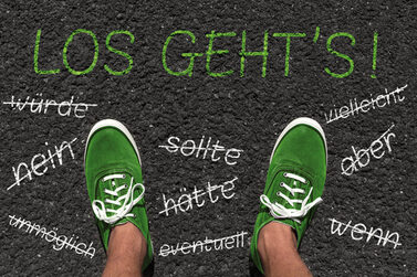 Zwei Fü0e mit grünen Schuhen stehen auf dem Asphalt. Wörter wie nein, aber, wenn in weißer Schrift auf grauem Asphalt sind durch gestrichen.