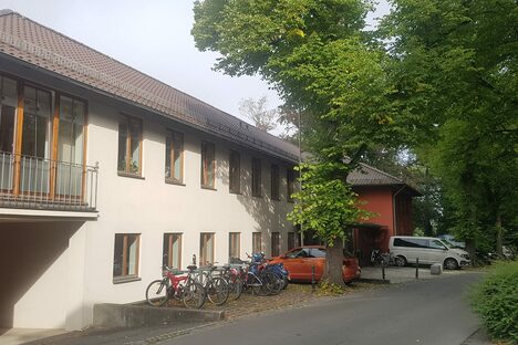 Das Bild zeigt die Aussenansicht der Geschäftsstelle der Evangelischen Jugend im Dekanat Coburg im Sommer, vor der Hausfront stehen mehrere Fahrräder