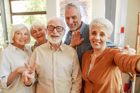 Eine Gruppe junggebliebener Senioren und Seniorinnen machen ein Selfie