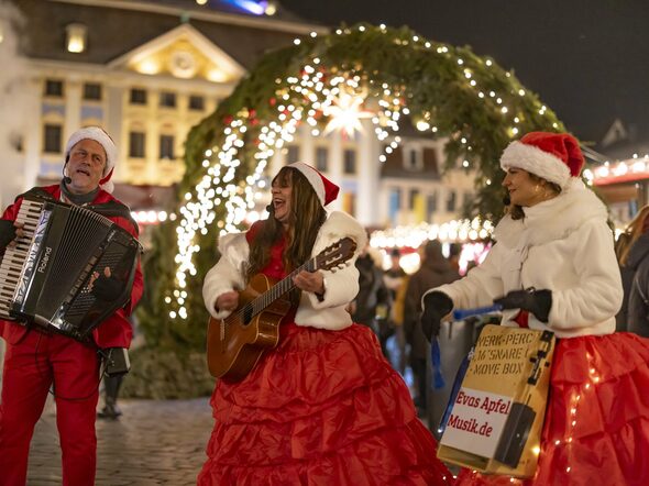 Musikalisches Trio mit Instrumenten vor dem Coburger Weihnachtsmarkt