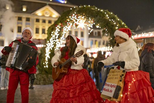 Musikalisches Trio mit Instrumenten vor dem Coburger Weihnachtsmarkt